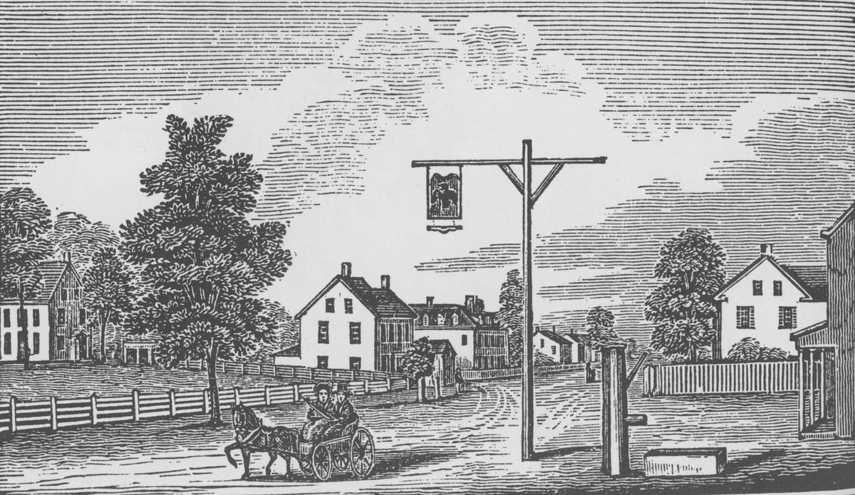 A wood engraving of the village: houses along a fenced road, a horse and carriage passing a tall signpost.