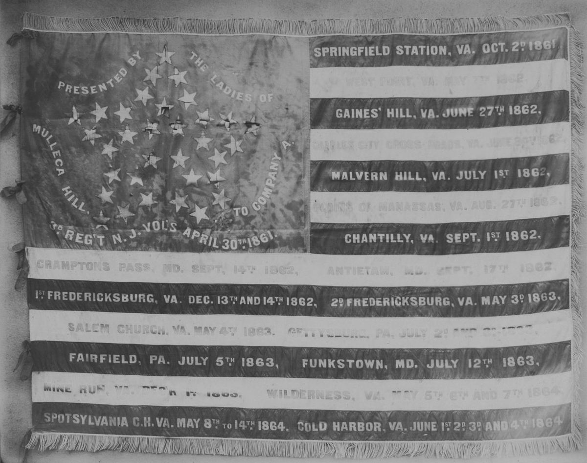 An American flag with battle names painted across its stripes, Springfield Station to Cold Harbor.
