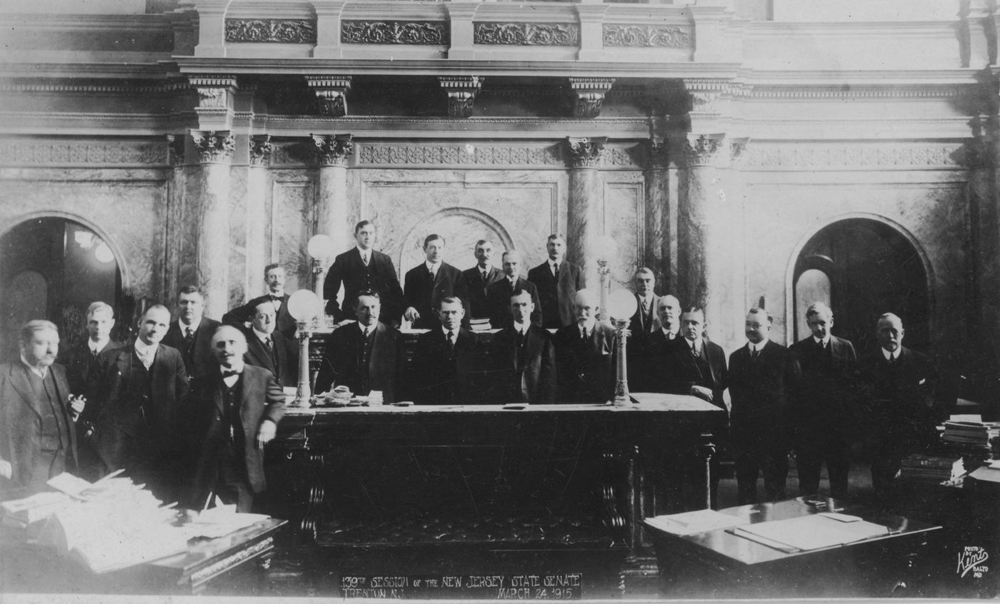 Senators posed standing around the marble rostrum of the Senate chamber.