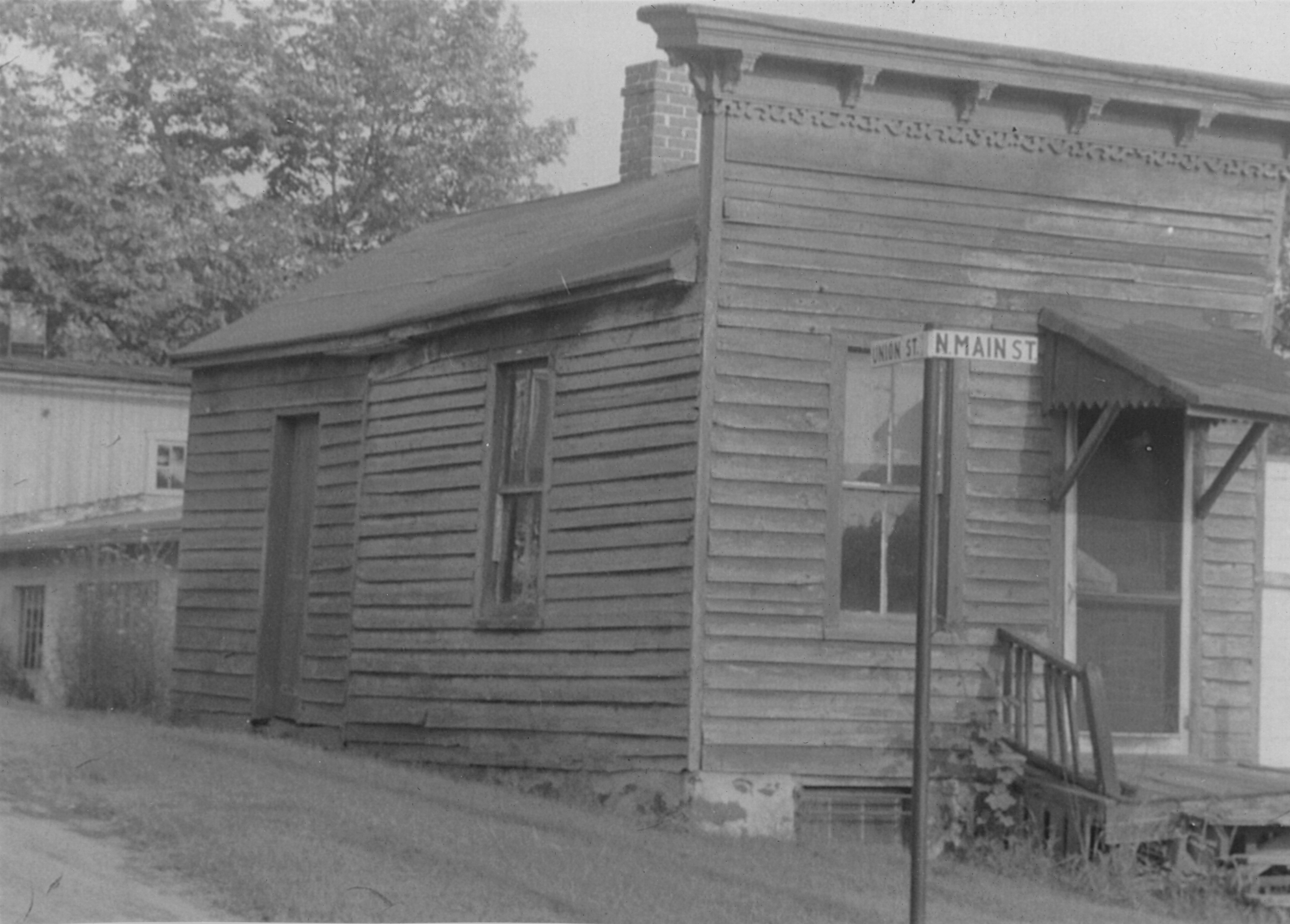 The frame building seen from the side street, a street sign reading Union St. and N. Main St. in front of its storefront corner.